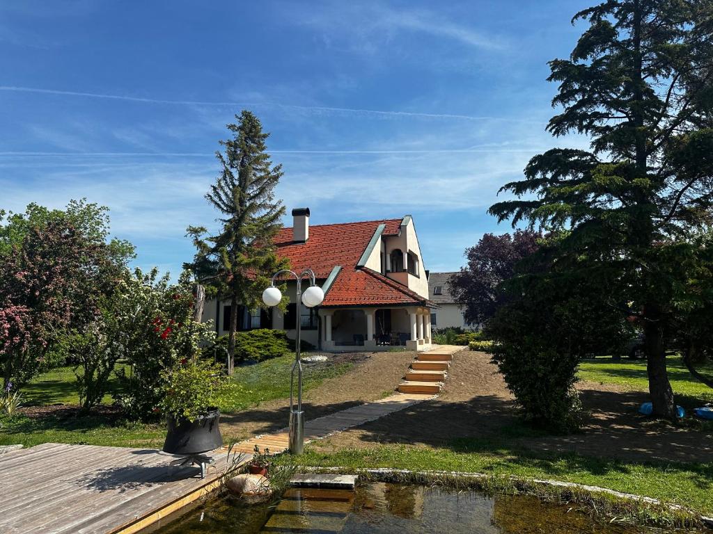 a house with a pond in front of it at Landhaus Pannonia in Trausdorf an der Wulka