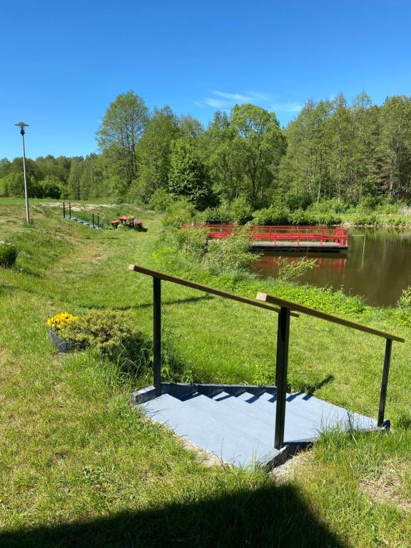 a bench on the side of a river with a boat at Agroturystyka Podlasie in Dobrzyniewo Duże