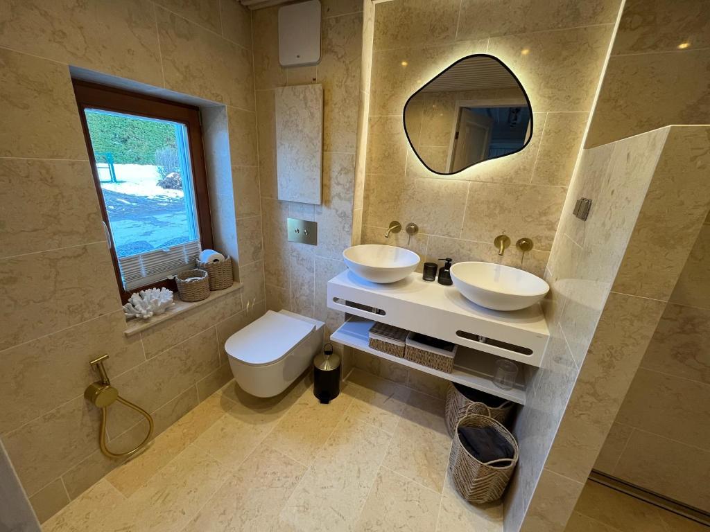 bagno con 2 lavandini, servizi igienici e finestra di Klaukse a Aabla