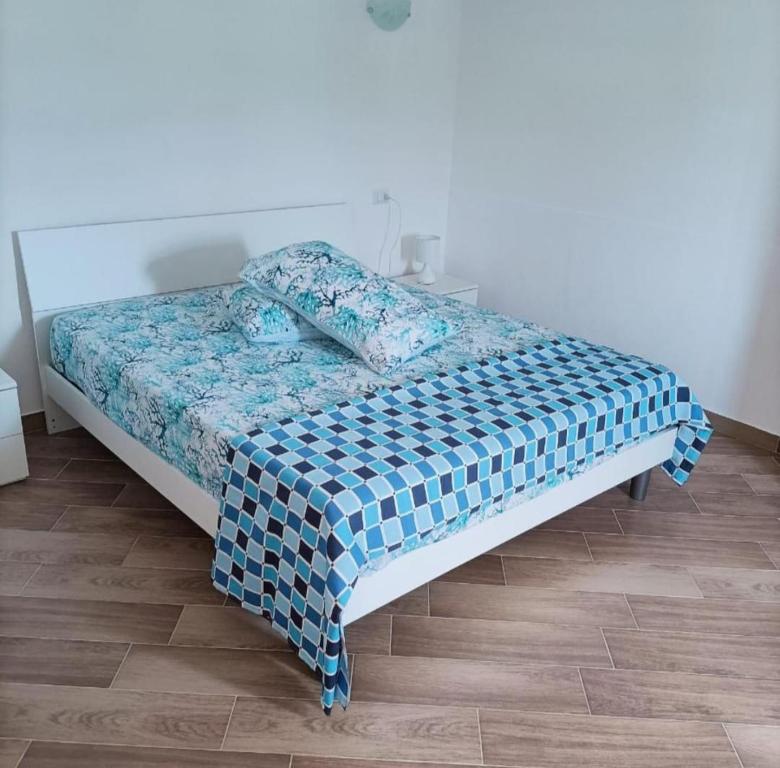 una camera con un letto e un piumone blu e bianco di Case vacanza Cilentane a Giungano
