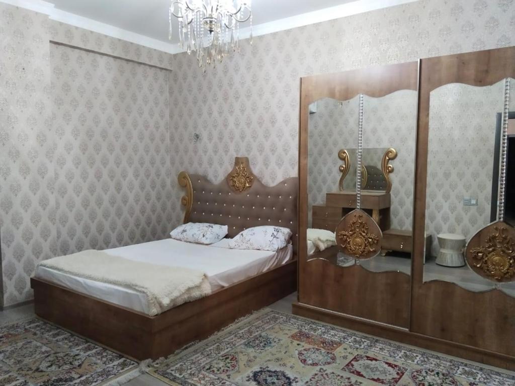 een slaapkamer met een bed en een kroonluchter bij 2 Bedrooms Apartment on 28 May Metro in Baku