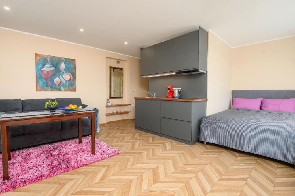 a bedroom with a bed and a desk and a kitchen at Ernakodu in Pärnu