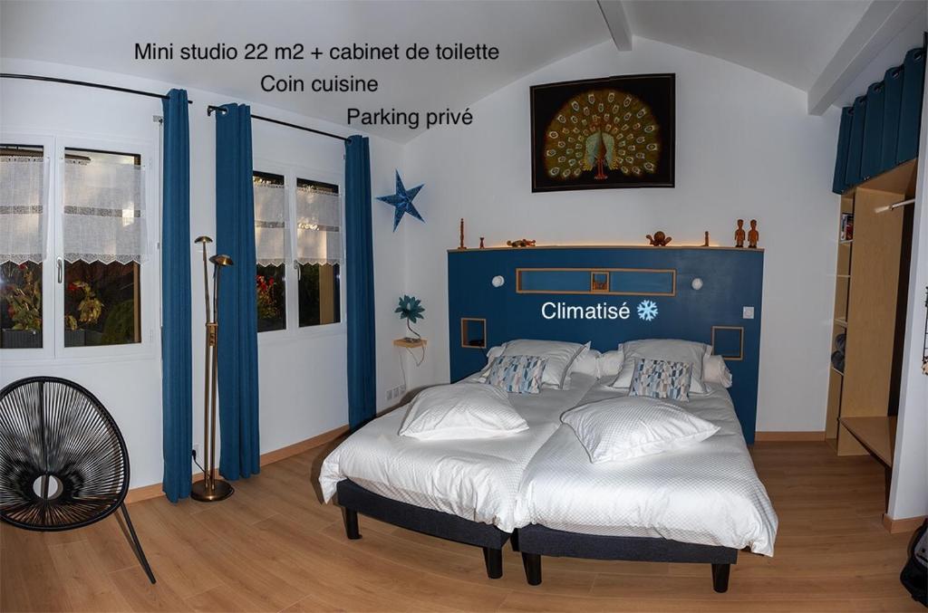 Schlafzimmer mit einem Bett mit blauem Kopfteil in der Unterkunft La Foulonnière de Neuville in Neuville-sur-Saône