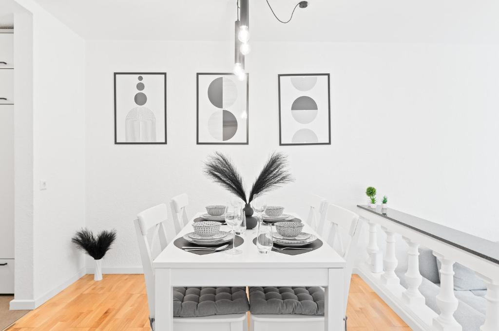- une salle à manger blanche avec une table et des chaises blanches dans l'établissement Kingsize Bett, Naturidylle, Netflix, Großräumig, à Pforzheim