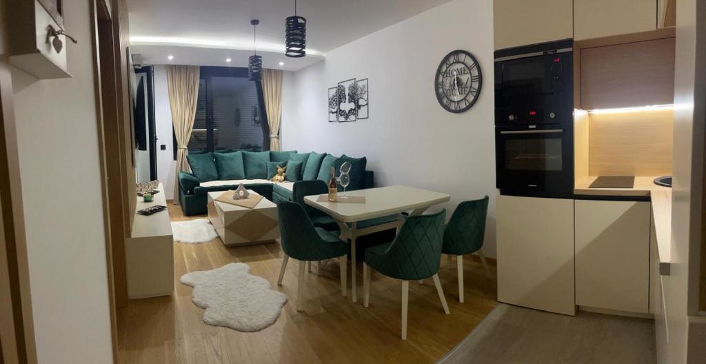 een keuken en een woonkamer met een tafel en stoelen bij Ema Lux in Zlatibor