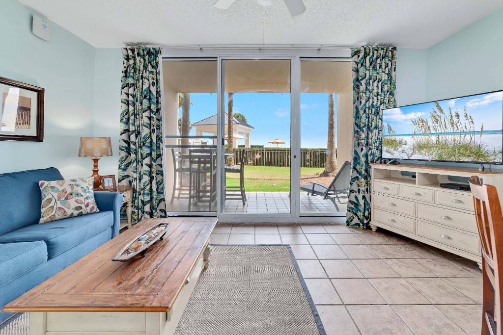 a living room with a blue couch and a tv at Beach Club C-102 in Gulf Shores
