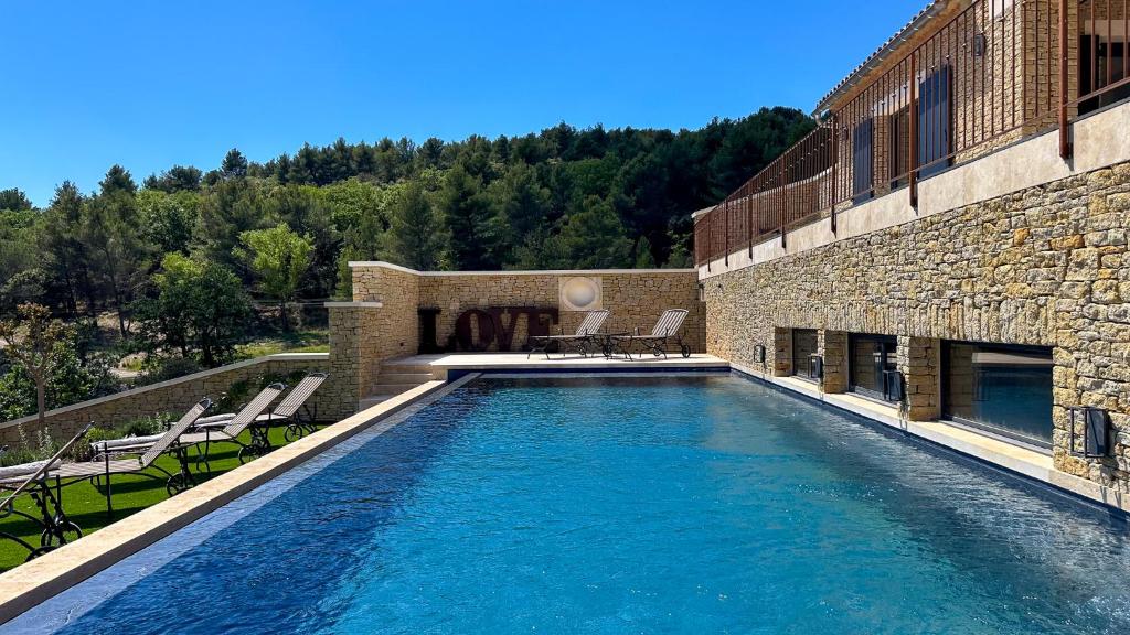 une piscine en face d'un bâtiment dans l'établissement Mas La Rose Sauvage - magnificent Luberon views, à Murs
