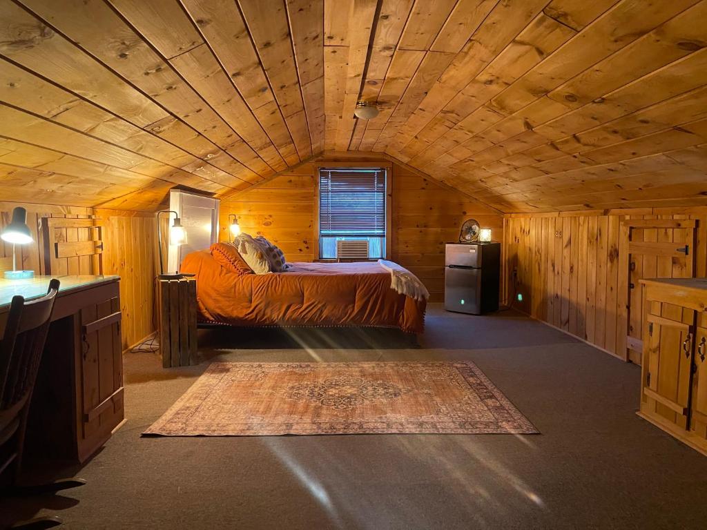 a bedroom with a bed in a wooden room at Country Roads cabin in Jamestown