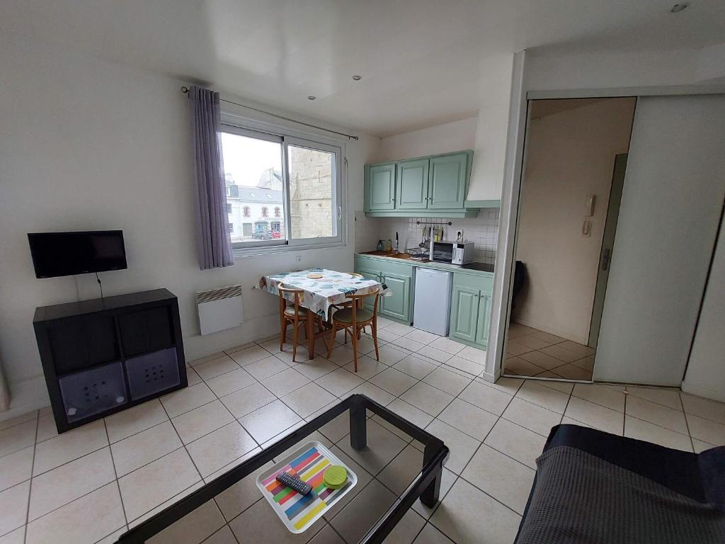 un salon avec une table et une cuisine dans l'établissement Larmor-Plage T1bis Notre-Dame, à Larmor-Plage