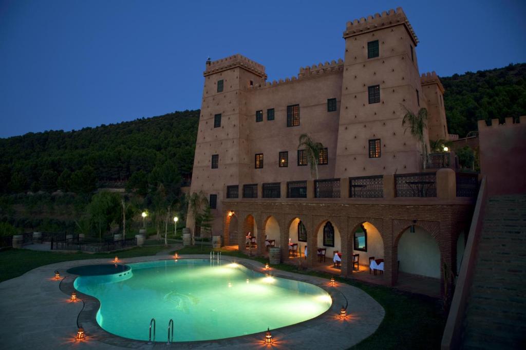 a large building with a swimming pool in front of it at Kasbah Illy in Demnat