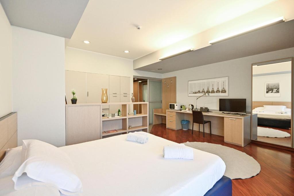 1 dormitorio con 1 cama blanca grande y cocina en Top Living Apartments - San Salvario, en Turín