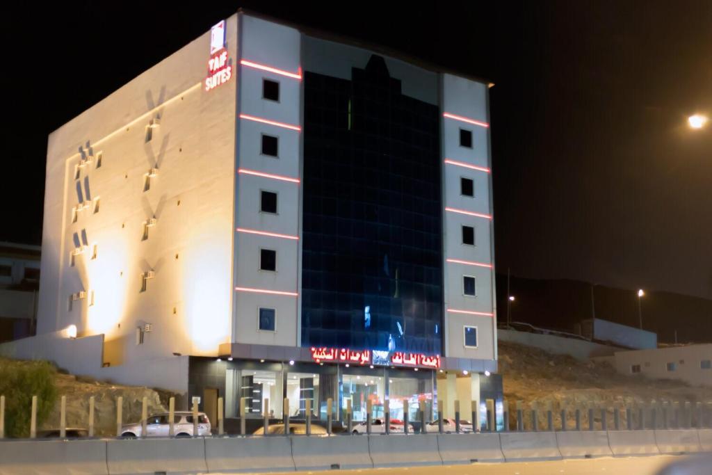 ein großes Gebäude mit einem Schild in der Nacht in der Unterkunft Al Taif Suites in Ta'if
