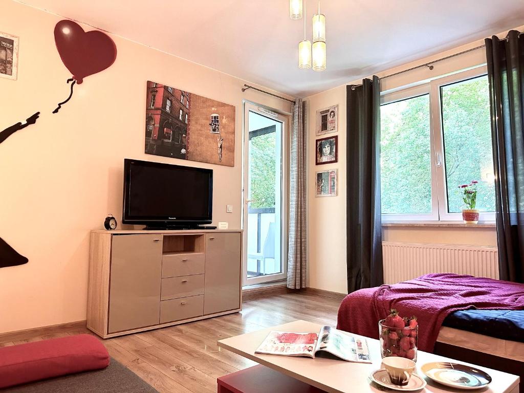 ein Wohnzimmer mit einem TV und einem Herzballon in der Unterkunft "Banksy" Art in Warschau