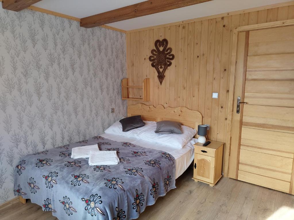 una camera con letto e parete in legno di Pokoje gościnne Jawor a Bukowina Tatrzańska