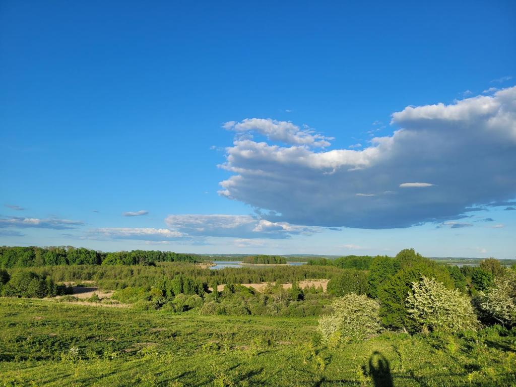 een luchtzicht op een groen veld met een blauwe lucht bij Wyskok 1 - dom z widokiem in Srokowo