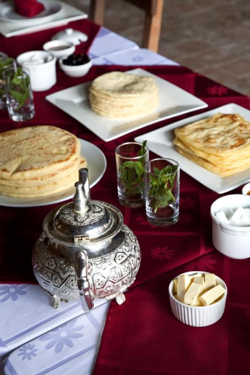 a table topped with plates of food on a red table at Kasbah Illy in Demnat