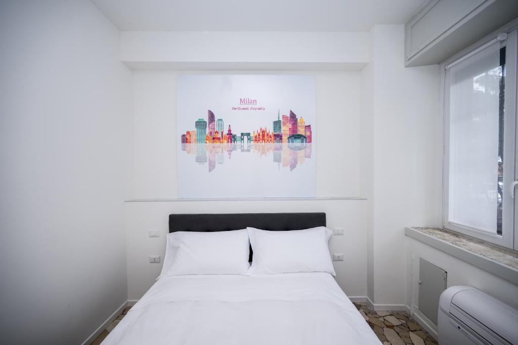 a bedroom with a white bed with a painting on the wall at Airguest Pianella Rooms in Milan