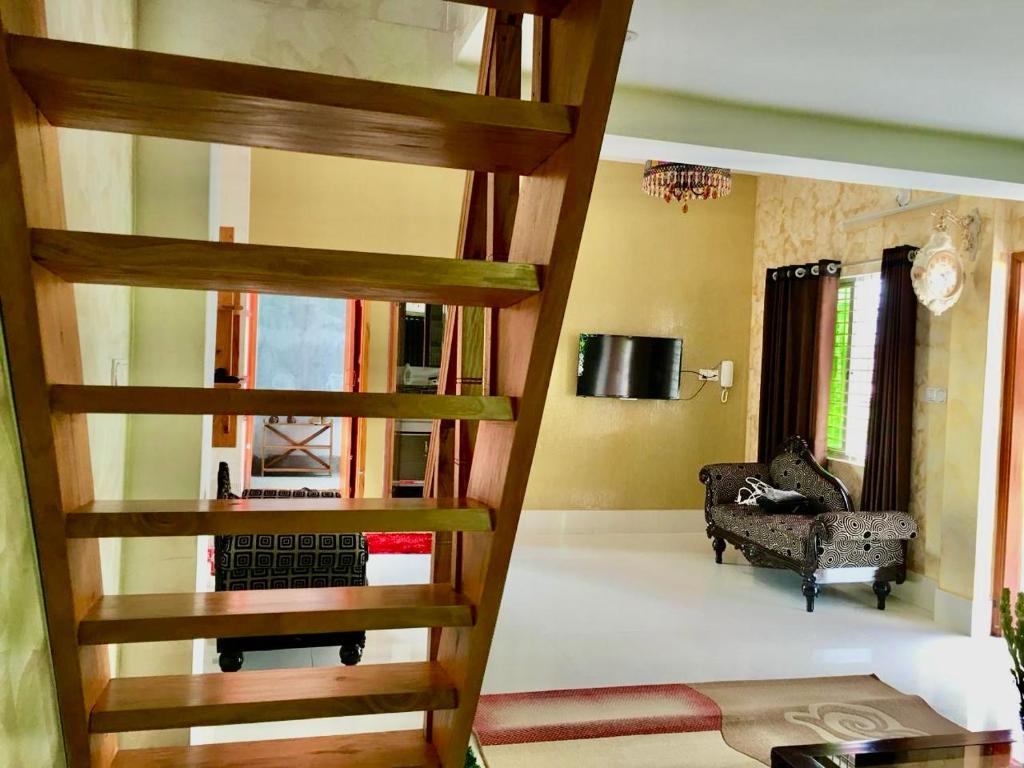 escalera de caracol en una sala de estar con sofá en Wahidul House, en Rājshāhi