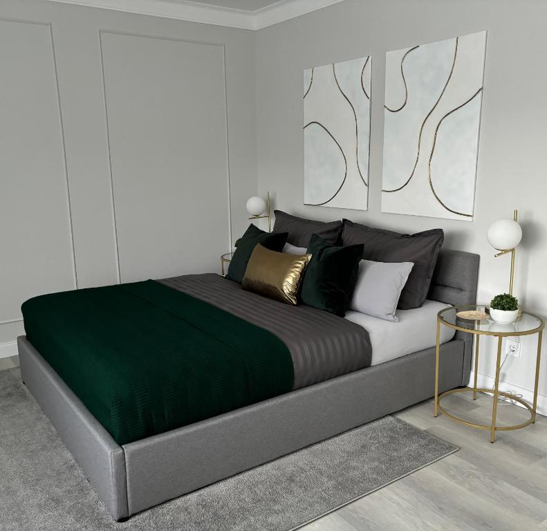 1 dormitorio con 1 cama grande con manta verde en Apartment Hartenrod en Bad Endbach