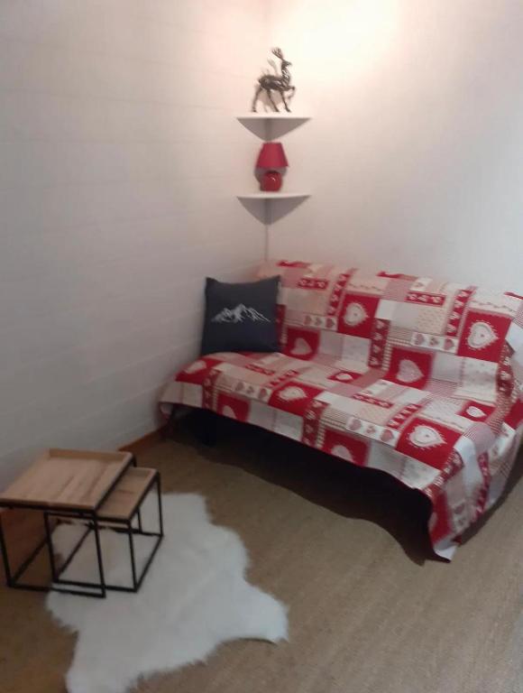 - une chambre dotée d'un lit avec une couverture rouge et blanche dans l'établissement Studio cozy, à Saint-Gervais-les-Bains
