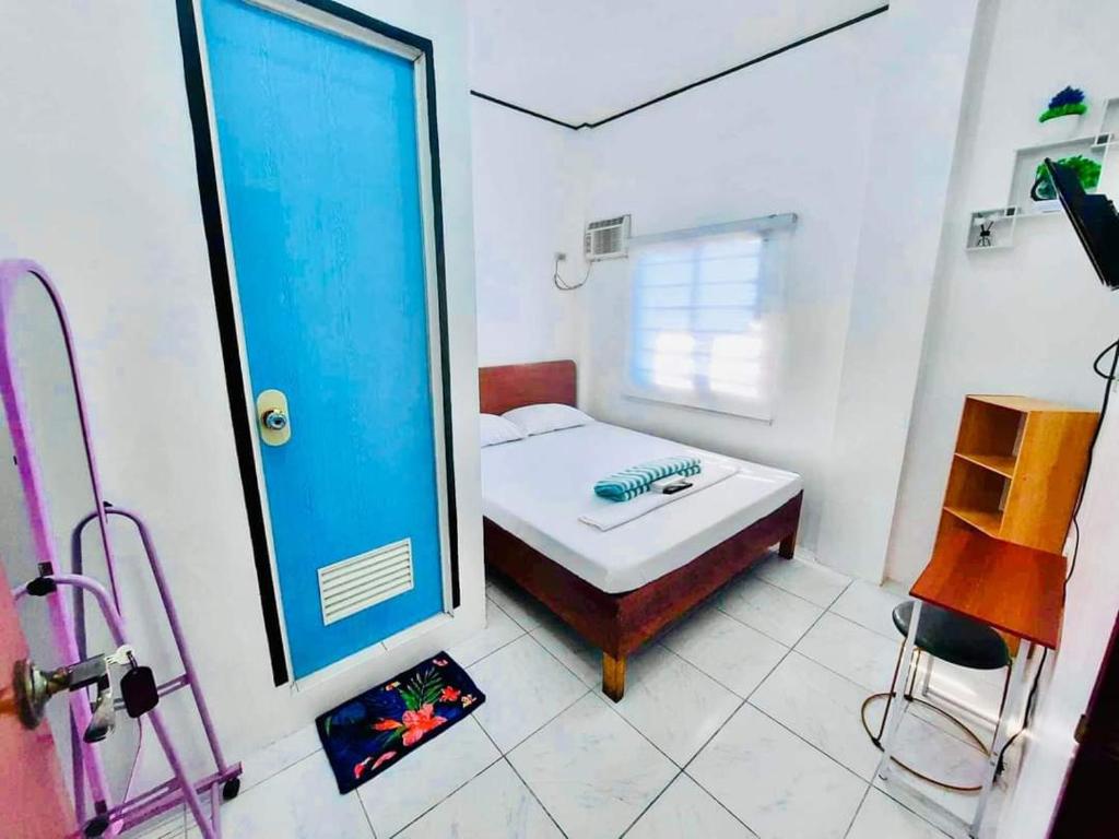 ein kleines Zimmer mit einem Bett und einem Spiegel in der Unterkunft Wakim’s INN in Coron