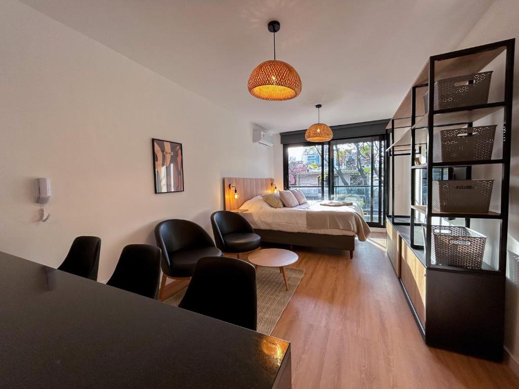 a bedroom with a bed and a table and chairs at Edificio M1 - Apartamentos frente a Punta Carretas Shopping - Gym Laundry Parrillero Solarium in Montevideo