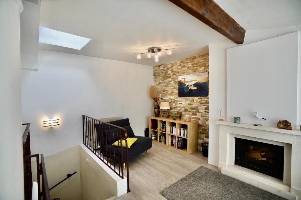 een woonkamer met een open haard en een trap bij La Mouette Bleue maison de ville individuelle in Martigues