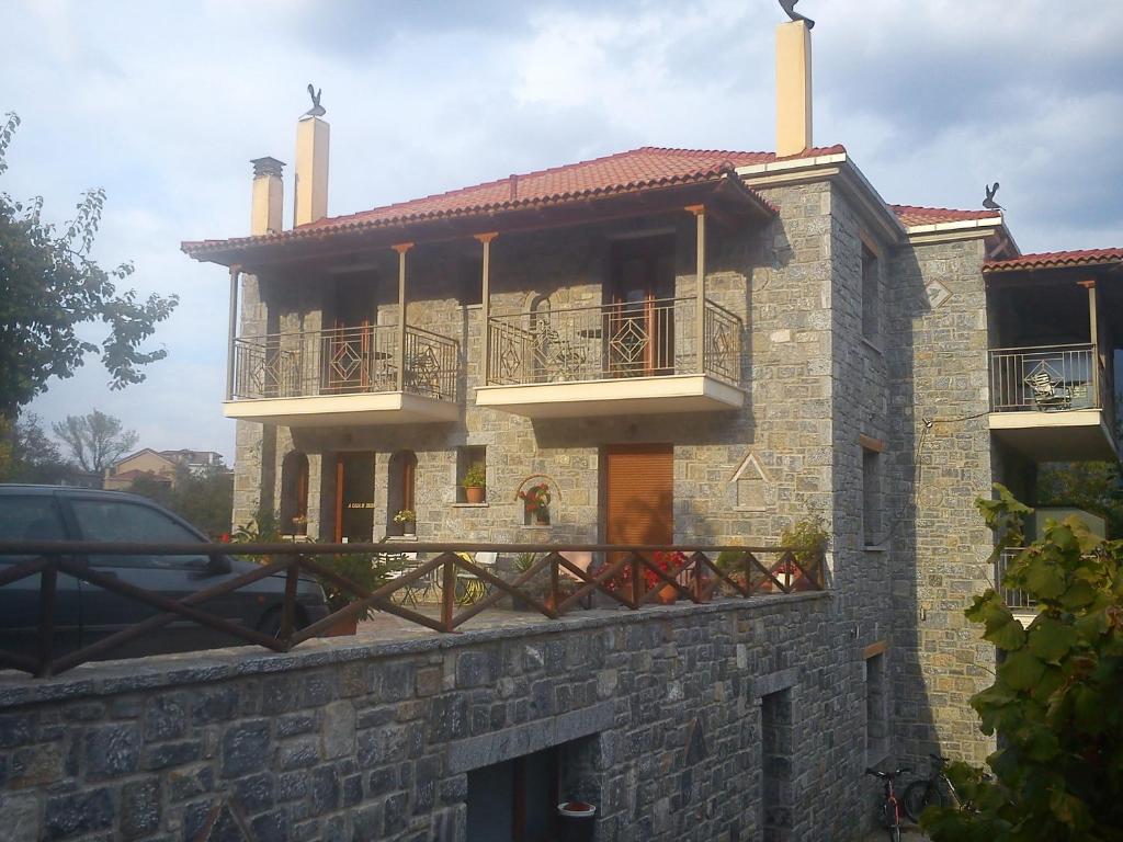 Casa de piedra con balcón en una pared de piedra en To Spiti tis Irinis, en Vitina