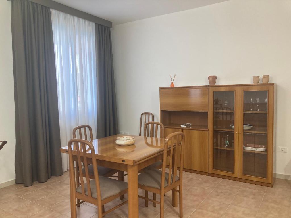 a dining room with a wooden table and chairs at La Ginestra Apartment in Marsala