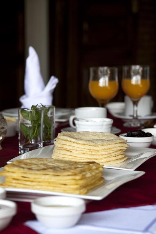a table with a plate of crackers and glasses of orange juice at Kasbah Illy in Demnat