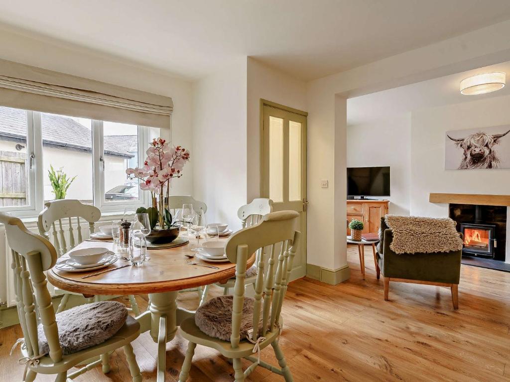 a dining room with a table and chairs and a fireplace at 3 Bed in Gilwern 91181 in Gilwern