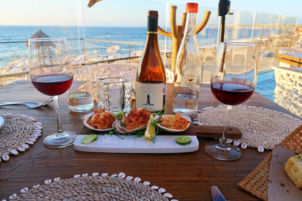 プエルト・バジャルタにある2BR condo in excellent location next to the beachのワイングラスとワイン1本付きのテーブル