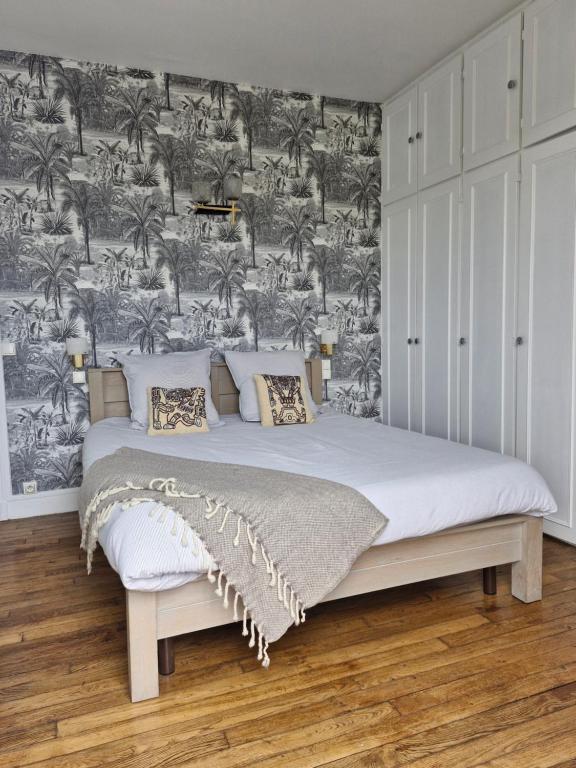 - une chambre avec un lit et du papier peint noir et blanc dans l'établissement A 18 min de Notre Dame au cœur de Paris en RER C, à Ivry-sur-Seine