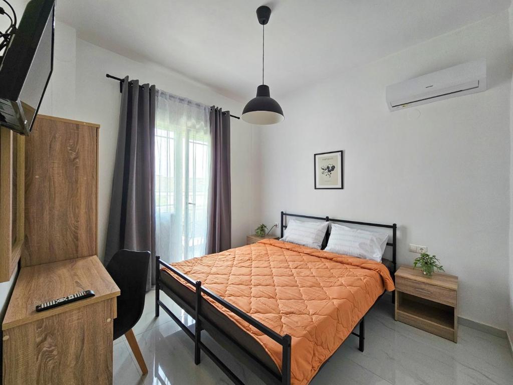 1 dormitorio con 1 cama con edredón de naranja en Exarhos Apartment, en Paralia Katerinis
