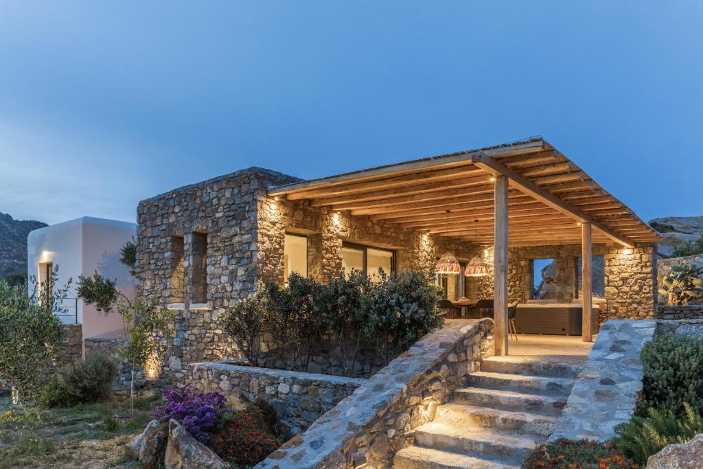 a stone house with a staircase leading up to it at Mykonos Cottage in Ano Mera