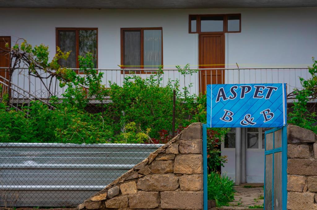una señal azul delante de una casa en Aspet B&B, en Tatʼev
