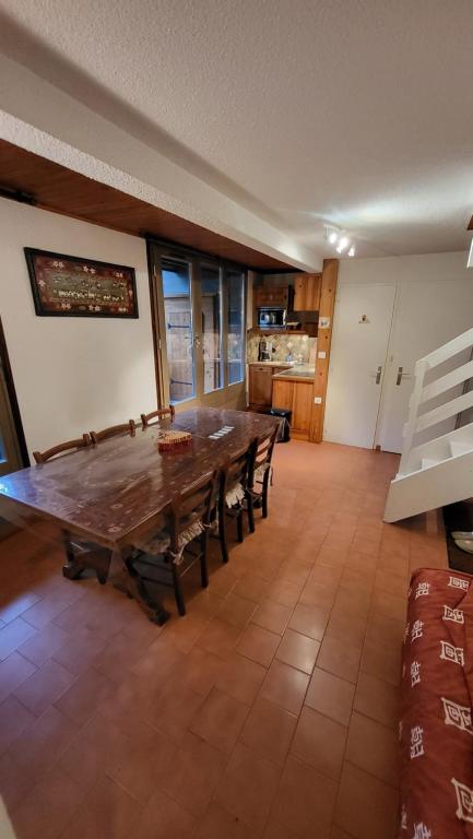 une grande salle à manger avec une table et des chaises en bois dans l'établissement Duplex au centre de la station, à Arâches-la-Frasse