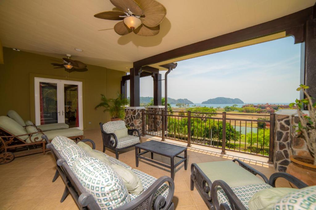 porche con sillas y balcón con vistas. en Los Suenos Resort Vista Bahia 3A by Stay in CR, en Herradura