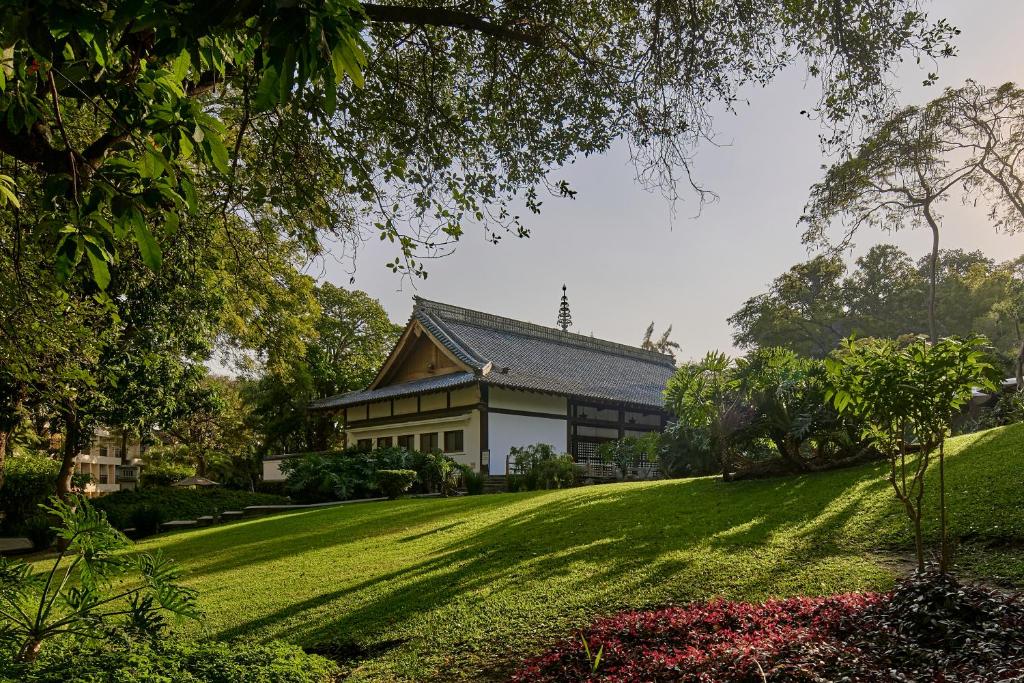 uma casa numa colina relvada com um jardim em Sumiya Cuernavaca em Cuernavaca