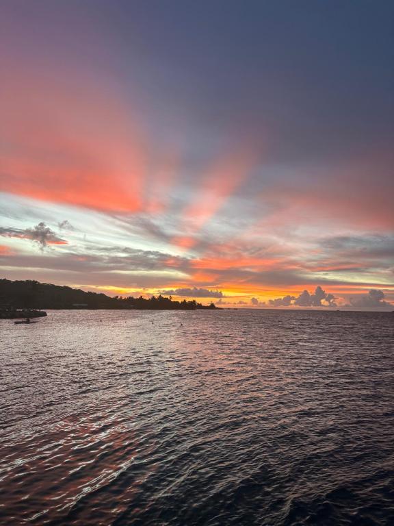a sunset over a body of water at B&B chez Anouk in Tevaitoa