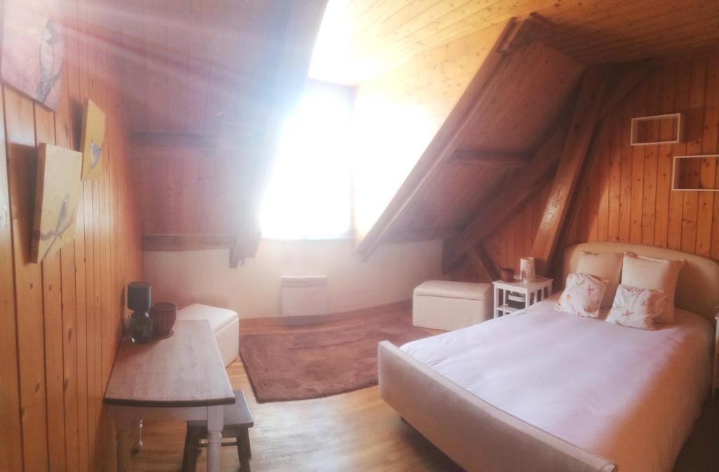 1 dormitorio con cama y ventana en el ático en Ambiance chalet Salles-Curan, en Salles-Curan
