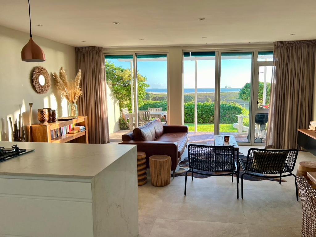 een woonkamer met een bank en een tafel bij Dolphin Beach Cabana in Table View