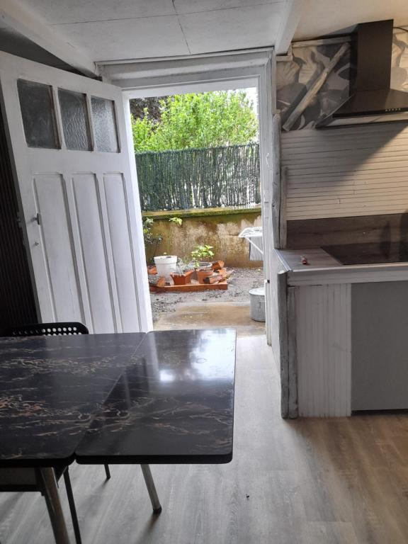 a kitchen with a table in front of a door at Smith Cosy in Châteaumeillant