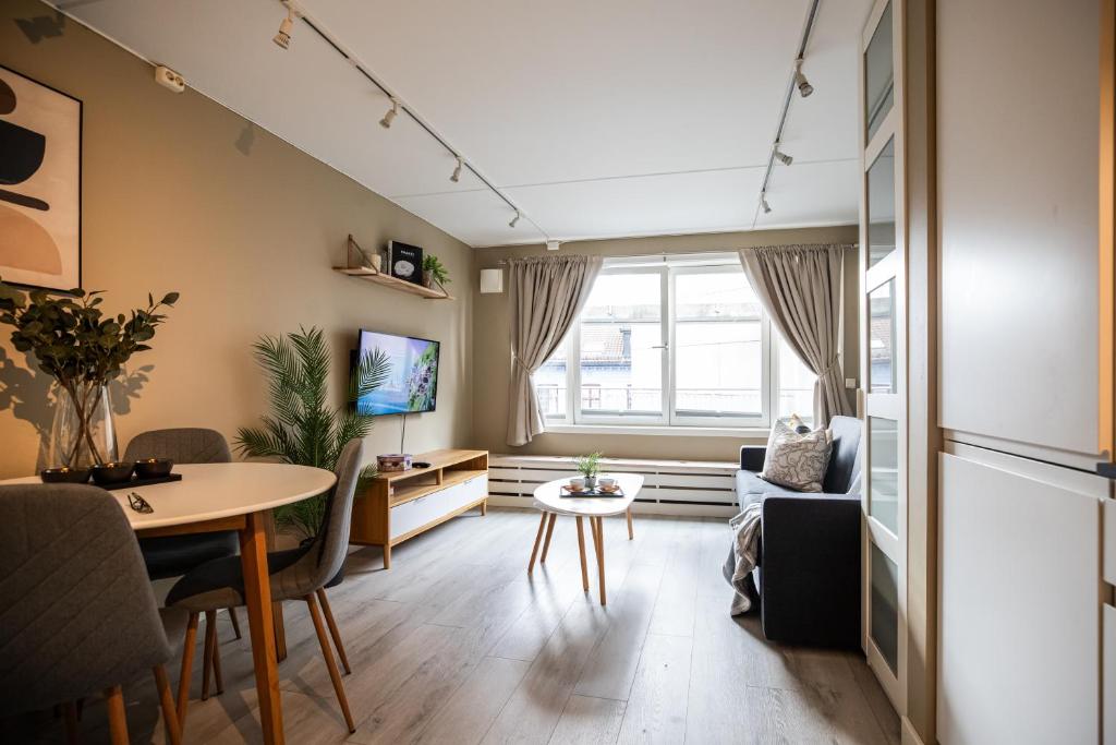 una pequeña sala de estar con mesa y sofá en Ultracentral duplex with private rooftop terrace, en Oslo