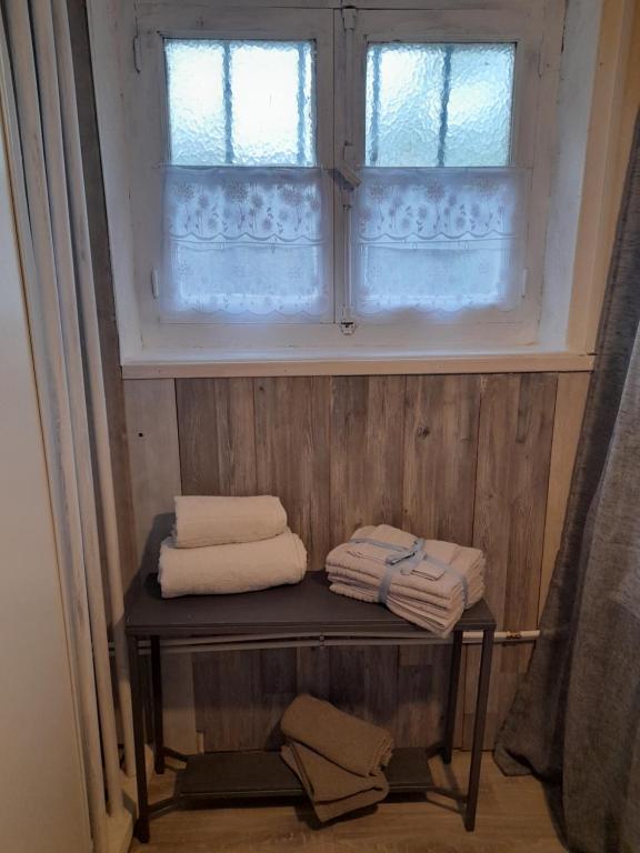 a bathroom with towels on a shelf in front of a window at Smith Cosy in Châteaumeillant