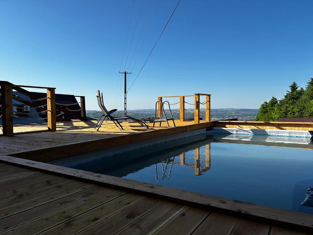 una piscina con parque infantil en una terraza de madera en Trzy Kopce 