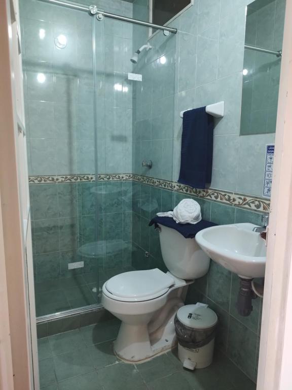 uma casa de banho com um WC, um lavatório e um chuveiro em Hostal Carvajal em Bogotá