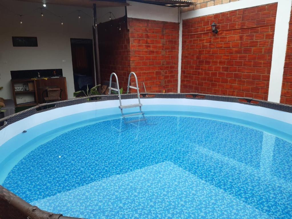 a large swimming pool in a room with a brick wall at Mítica, Casa Vacacional in Sauce