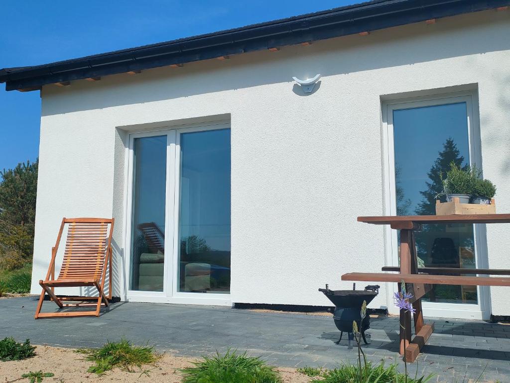 a house with glass doors and a chair on a patio at Modlinek 8a in Ustka