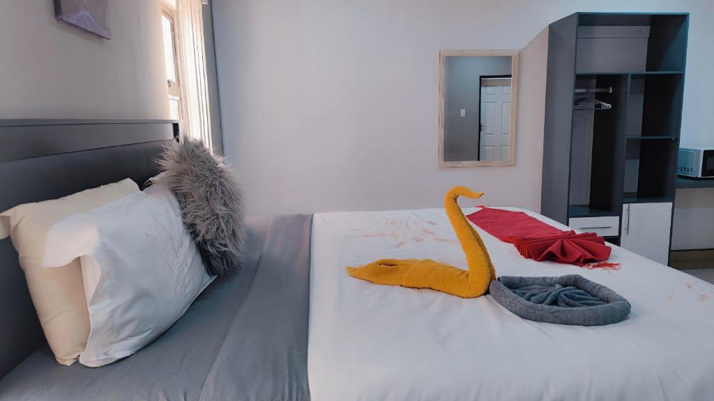 sypialnia z łóżkiem z wypchanym zwierzakiem w obiekcie Royal Home Guesthouse w mieście Maun